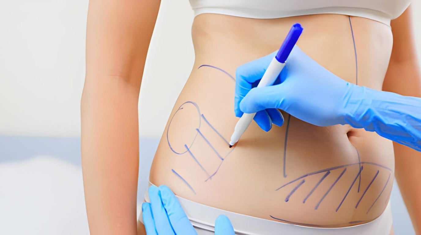 A close-up of a woman receiving a stomach tattoo, with the artist focused on the detailed artwork.